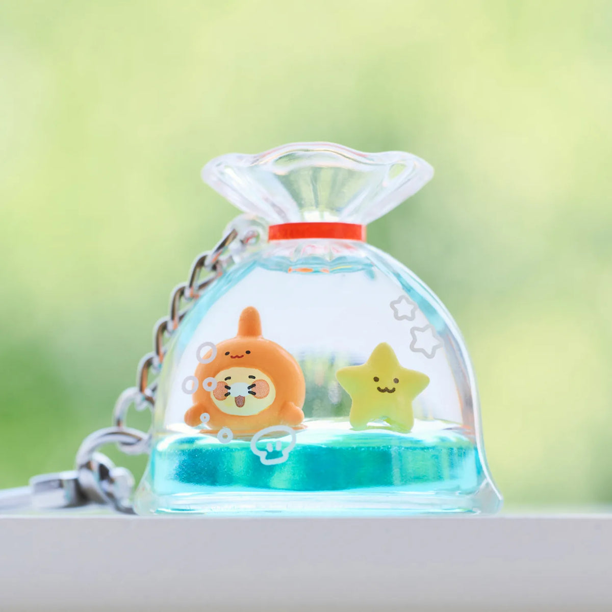 Add a playful touch to your everyday accessories with the Kakao Friends - Chunsik Fish Tank Keyring.